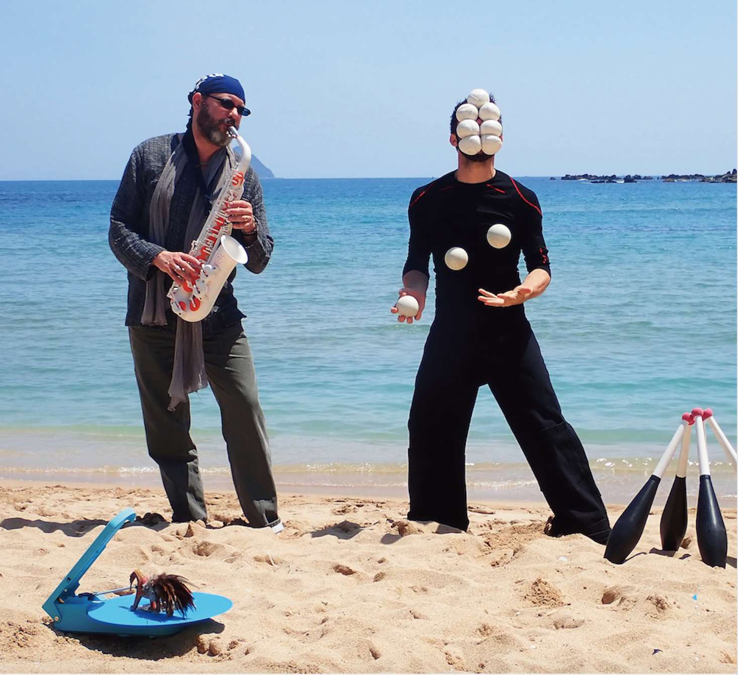 Arnaud Lechat on saxophone and Valentin Lechat juggling during the Faces Ocean show